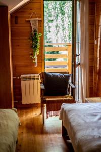 a room with two beds and a chair and a window at Sielski Dworek in Chodel