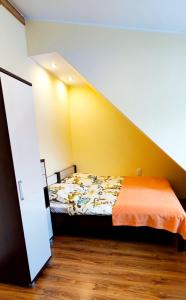a bedroom with a bed with a yellow wall at Pokoje Gościnne Sonea in Lewin Kłodzki