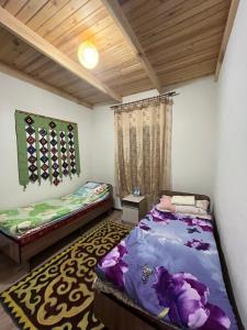 een slaapkamer met 2 bedden en een tapijt bij Guest House Guljan in Bokonbayevo