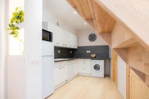 a kitchen with white cabinets and a washer and dryer at Joli T3 en Duplex avec terrasse #6 in Embrun