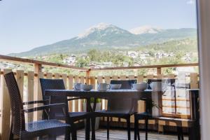 a table and chairs on a balcony with mountains in the background at Joli T3 en Duplex avec terrasse #6 in Embrun