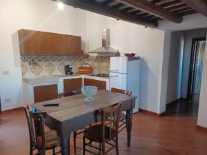 a kitchen with a table and chairs and a refrigerator at La Casa di Cofano in Custonaci