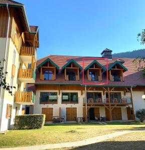 an exterior view of a house with a red roof at LE NID DU BIRDIE, Giez, Proche du lac d’Annecy in Giez