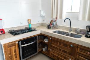 a kitchen with a sink and a stove at Casa Santorini Terrace in Arraial do Cabo +15 photos