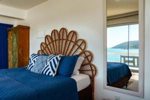 a bedroom with a bed with a large mirror at Casa Santorini Terrace in Arraial do Cabo