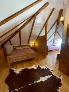 a attic room with two beds and a rug at Kuca pod Rudnikom in Trudelj