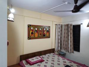 a bedroom with a bed and a painting on the wall at Nivaant @ Vicharays in Alibaug