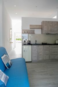 eine Küche mit blauem Sofa in einem Zimmer in der Unterkunft Blue Side Studios in Pefki