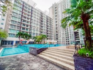 a swimming pool in front of a large building at Mutiara Ville Cyberjaya by Idealhub in Cyberjaya