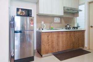 a kitchen with a stainless steel refrigerator and a sink at Mutiara Ville Cyberjaya by Idealhub in Cyberjaya