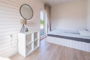 a bedroom with a bed and a mirror at Sodyba "Bičiuliai" in Plungė