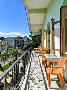a balcony with tables and chairs on a building at Green House in K'obulet'i