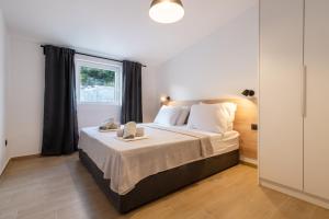 Schlafzimmer mit einem großen Bett und einem Fenster in der Unterkunft Apartmani Nocturno in Neum