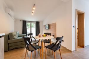 ein Esszimmer und ein Wohnzimmer mit einem Tisch und Stühlen in der Unterkunft Apartmani Nocturno in Neum