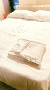 Una cama blanca con dos almohadas blancas. en La nicchia di Mary, en Bisceglie
