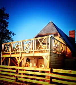 une grande maison en bois avec un toit en gambrel dans l'établissement Studio de charme avec piscine de relaxation, à Moyaux