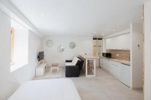 Habitación blanca con cama blanca y cocina en Magnifique Loft Balnéo Hammam #3, en Embrun