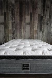 a mattress in a room with a wooden wall at Le 2020 Charlevoix in La Malbaie