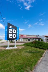 a sign in the grass in front of a building at Le 2020 Charlevoix in La Malbaie