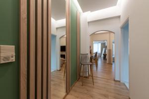 a hallway with green and white walls and a table and chairs at MEDLUXE BUSINESS Apartment in Athens