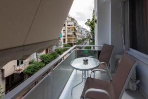 a balcony with a table and chairs on a building at MEDLUXE BUSINESS Apartment in Athens