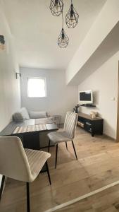 een woonkamer met een tafel en stoelen en een bed bij Apartments Milas in Trogir