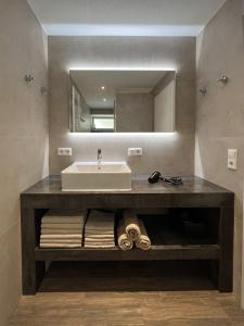 La salle de bains est pourvue d'un lavabo et d'un miroir. dans l'établissement Apartment Tomm by Europa-Park & Rulantica, à Rust