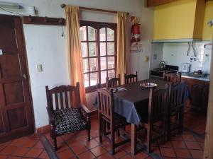 Una cocina con una mesa y sillas en una cocina. en Cabañas Tierra Linda, en Concepción del Uruguay