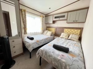 a small bedroom with two beds and a window at Honeysuckle Hot Tub Lodge in South Cerney +47 photos