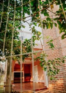 a brick building with a tree in front of it at Complejo Familiar EL VIEJO MOLINO in Paso de la Patria