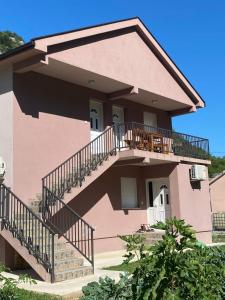 een groot roze huis met een trap ervoor bij Riverside in Virpazar