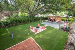 a backyard with a lawn with chairs and a swing at Beautiful House, Walking Distance to Stadium in Tampa