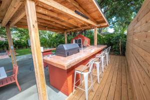 a patio with a bar with a grill and chairs at Beautiful House, Walking Distance to Stadium in Tampa