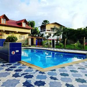 a swimming pool in front of a house at Palmendros Hosteria in Montañita