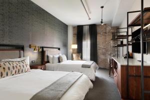 a hotel room with two beds and a desk at Hewing Hotel in Minneapolis