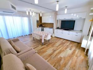 Televízia a/alebo spoločenská miestnosť v ubytovaní Royal Sea House