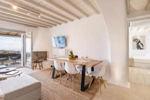 uma cozinha e sala de estar com mesa e cadeiras em Hyperion Villa by LLB Mykonos em Klouvas