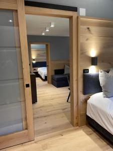 a room with a bed and a mirror and a bedroom at Hotel Rech-Hof Sayonara in Folgaria