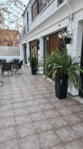 un patio con sillas y macetas frente a un edificio en Uvas Apart Hotel en Mendoza