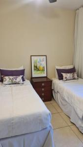 dos camas sentadas una al lado de la otra en una habitación en Uvas Apart Hotel en Mendoza