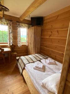 ein Schlafzimmer mit einem Bett in einem Holzzimmer in der Unterkunft Ku Sośnie 2 in Rzepiska