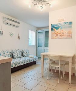 - un salon avec un canapé et une table dans l'établissement Appartamento Perla Marina, à Sottomarina