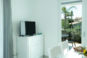 a tv on top of a white cabinet in a living room at Casa Antonello in Golfo Aranci