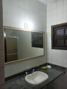 a bathroom with a sink and a mirror at Hotel Pierre in Itaguaí