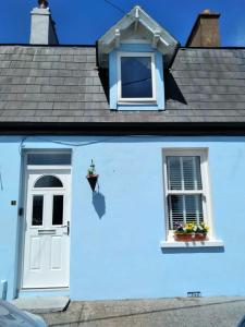 a white house with a window and a door at Sea View Cottage, 2 bedrooms with stunning views in Cobh