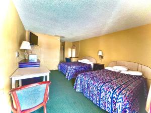 a hotel room with two beds and a desk at Tropic Motel in Aransas Pass