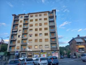 een hoog gebouw met auto's geparkeerd voor het bij Serravalle Apartment in Serravalle Scrivia