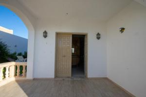 an empty room with a door and a balcony at Villa meublée avec piscine et abri de voiture in Erriadh