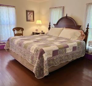 een slaapkamer met een groot bed en een stoel bij Ozark Country Inn in Mountain View