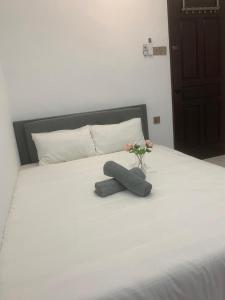 uma cama branca com um vaso com flores em Newly Renovated (Trial Price Now) Bukit Mertajam em Bukit Mertajam